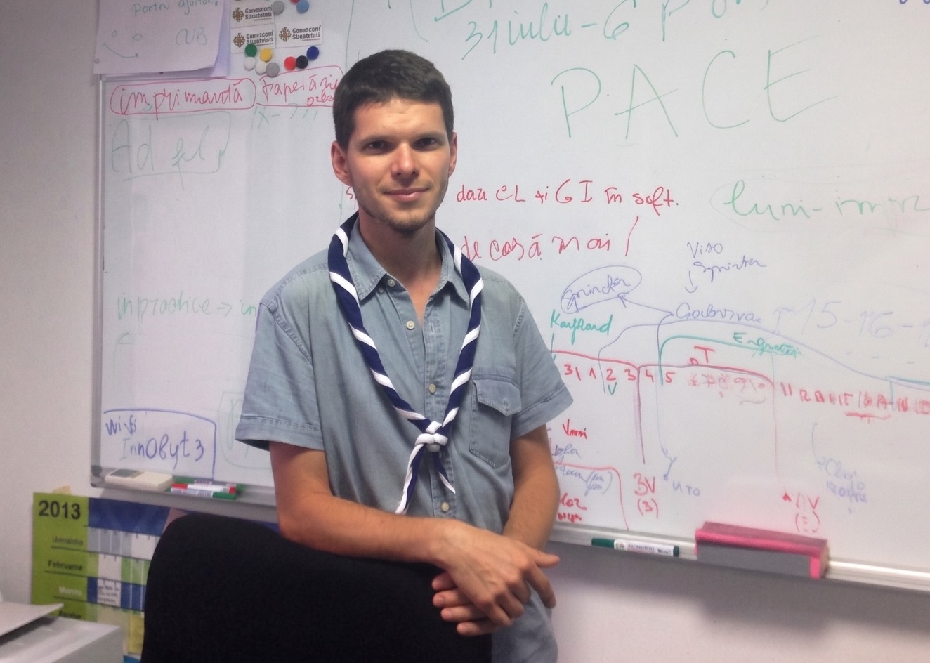 Vasile Darie in 2013, in Romanian Scouts uniform, in front of the planning board where Orgo started.